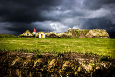 View of castle on field against cloudy sky