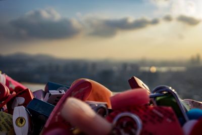 Close-up of padlocks on bridge against sky