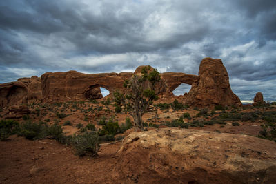 Rock formations on landscape against cloudy sky