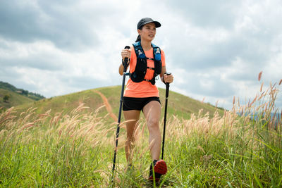 Young woman walking on grassy land