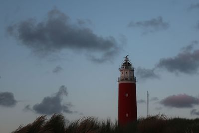 Lighthouse by sea against sky