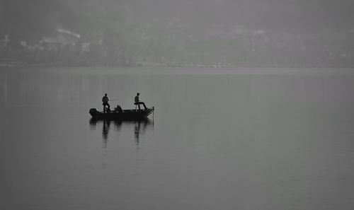 People in boat on sea against sky