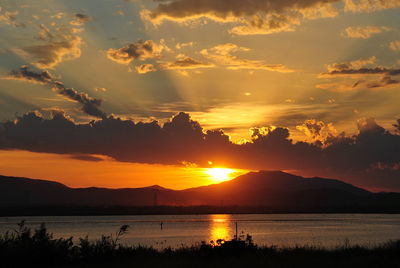 Scenic view of lake against romantic sky at sunset