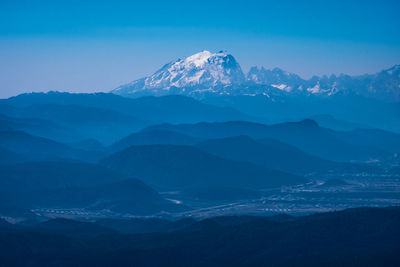 Scenic view of snowcapped mountains against blue sky