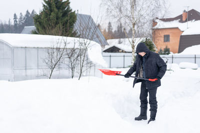 Rear view of man skiing on snow covered field