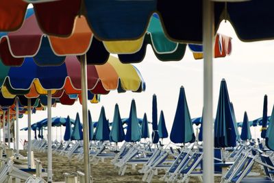 Panoramic shot of multi colored umbrellas on beach against sky