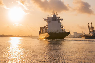 Ship sailing in sea against sky during sunset