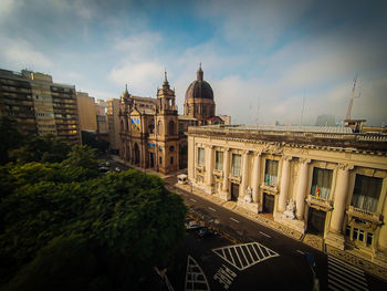 Buildings in city against cloudy sky