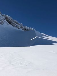 Snowcapped mountains against clear blue sky