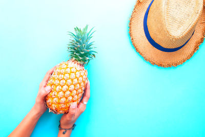 Midsection of person holding ice cream against blue background