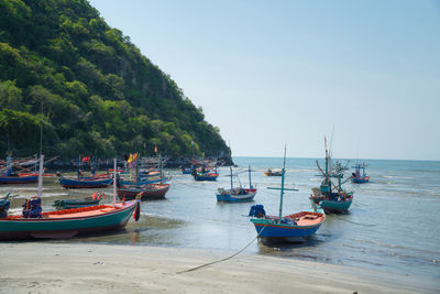 Boats moored on sea against sky