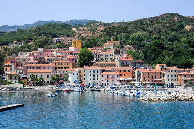 Buildings by sea against sky