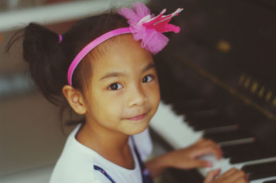 Portrait of cute girl playing piano