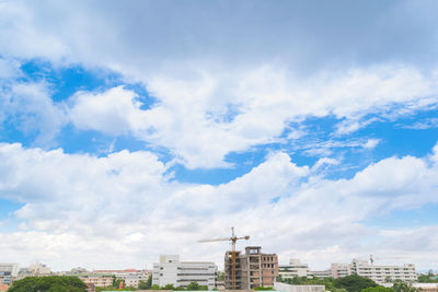 Buildings in city against cloudy sky