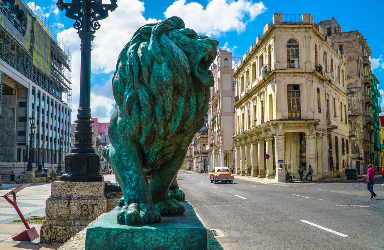 STATUE ON STREET BY BUILDINGS IN CITY