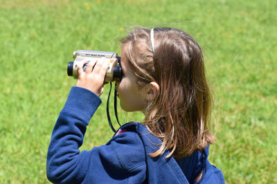 Portrait of woman holding mobile phone in field