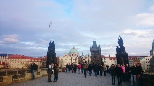 People at town square against sky in city