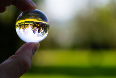 Close-up of hand holding crystal ball