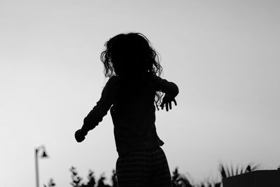 Rear view of girl jumping at beach