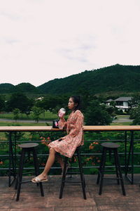 Woman sitting on seat in park