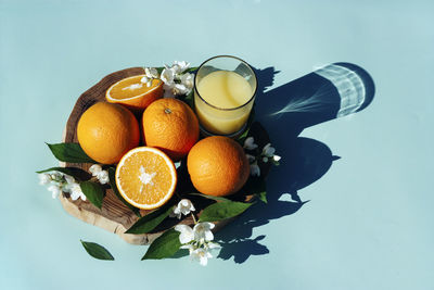 Citrus juice with oranges on plain background