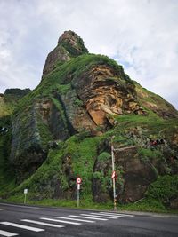 Rock formations by road against sky