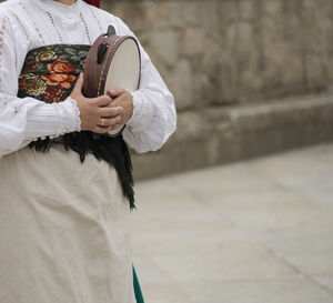 Midsection of woman holding musical instrument