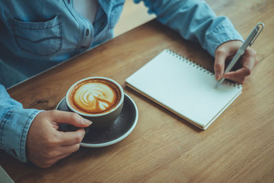 Midsection of coffee cup on table