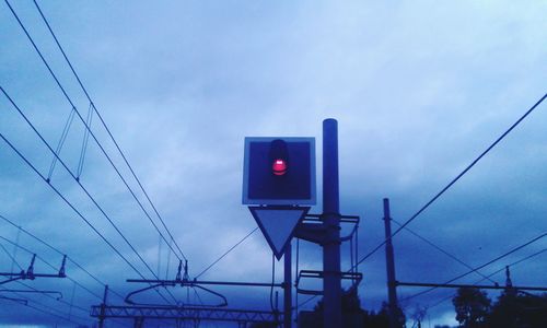 Low angle view of electricity pylon against blue sky