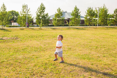 Full length of girl playing on grassy field