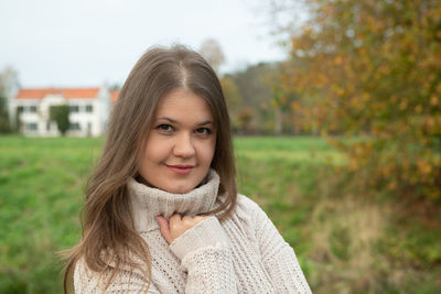 Portrait of beautiful young woman on field during autumn