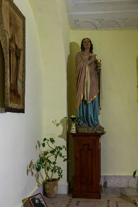 Statue of buddha against wall in building