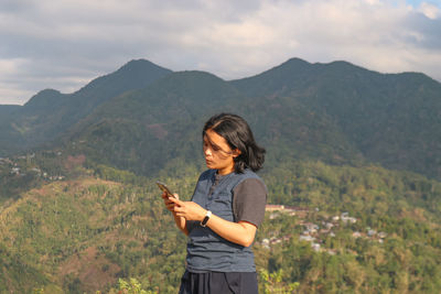 Side view of woman standing on mountain