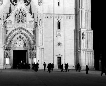 People walking by zagreb cathedral at night