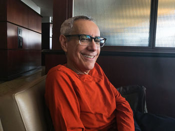 Smiling senior man wearing eyeglasses sitting at home