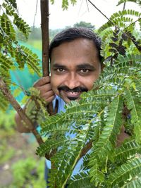 Portrait of man standing amidst plants