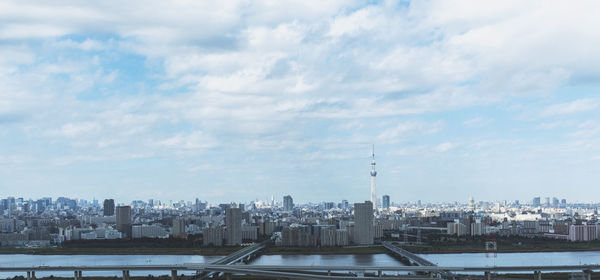 Buildings in city against cloudy sky