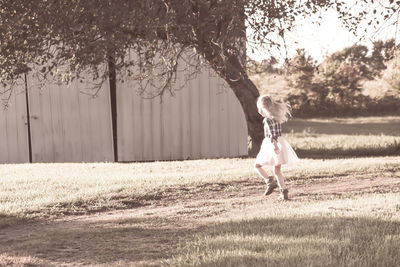 Full length of girl jumping on field