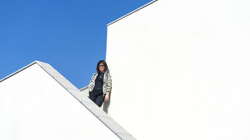 Woman leaning on the white walls