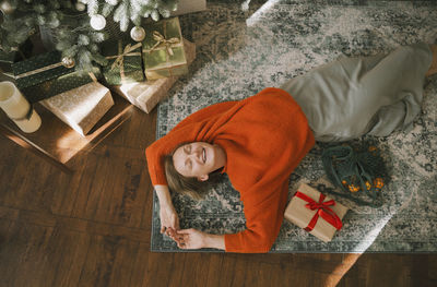 Smiling woman lying down on carpet at home