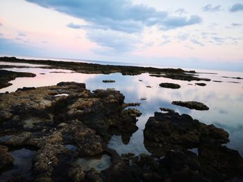 Rocks in sea against sky