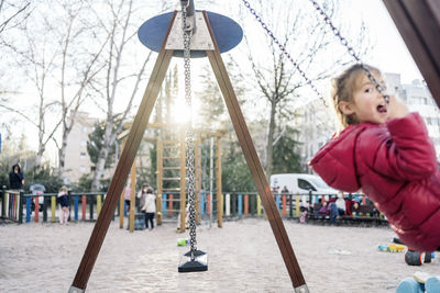 Rear view of girl looking at playground