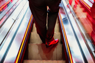 Low section of man standing on escalator