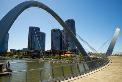 Bridge over river against sky in city