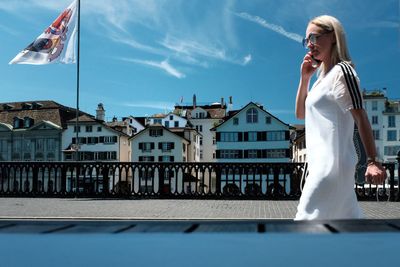 Woman with flag against built structure