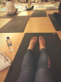 Low section of woman relaxing on tiled floor