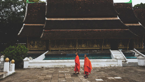 Rear view of people walking at temple