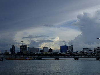 City buildings by sea against sky