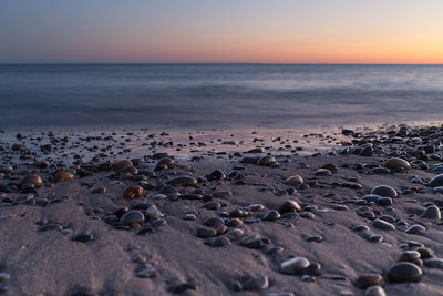 Surface level view of sea shore at sunset