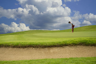 Full length of person on golf course against sky